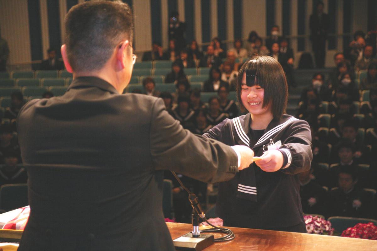 小野田校長から卒業証書を笑顔で受け取る卒業生