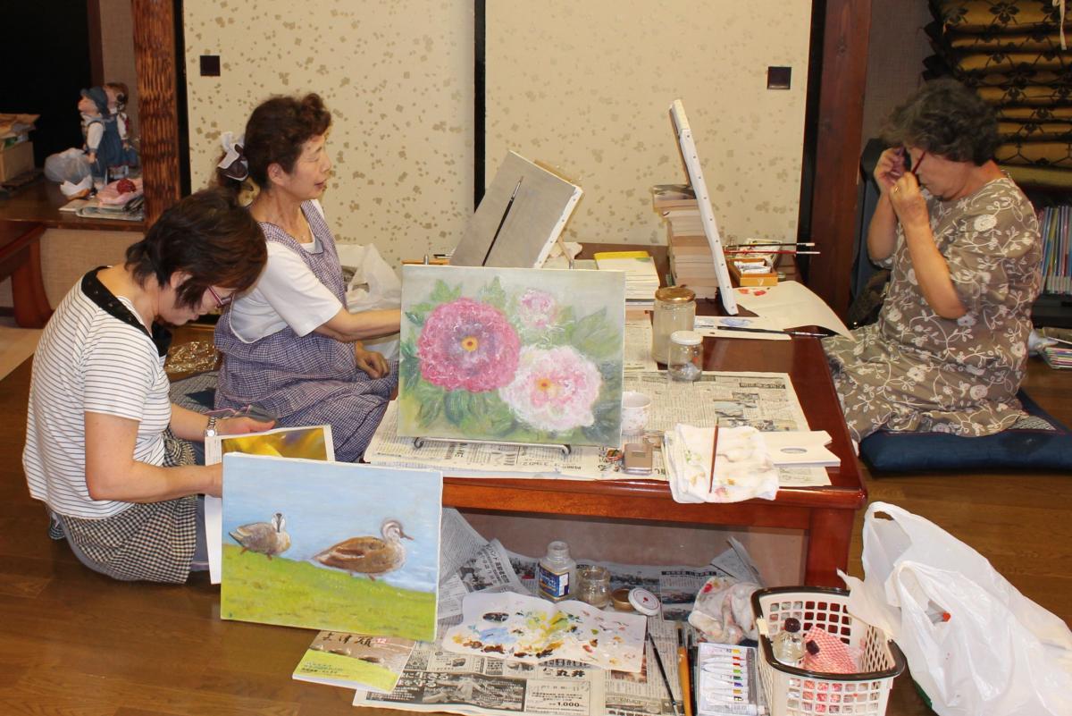 写真や雑誌の切り抜きを題材に、構図や色を工夫して作品を制作する婦人会のメンバー（2）