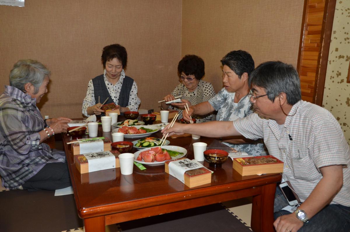 昼食に振る舞われたお弁当、すいとん、会津美里町産のトマトを味わう参加者