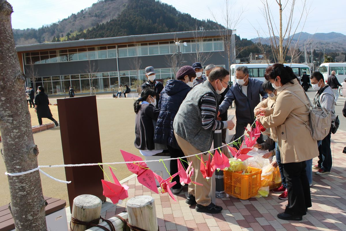 町民らが集まり折り鶴にメッセージを書いて飾り付けました。