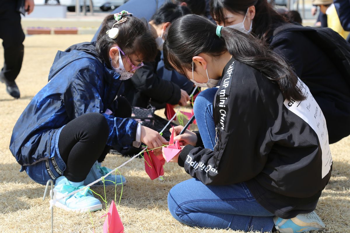 追悼イベントの準備を手伝った町立小の児童。折り鶴にメッセージを書きました。
