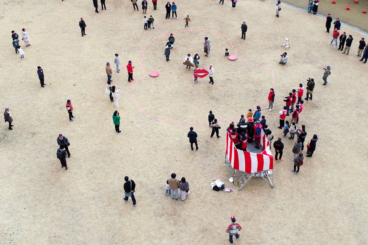 大熊町役場前広場で行われた巨大福笑いゲームに挑戦する参加者。