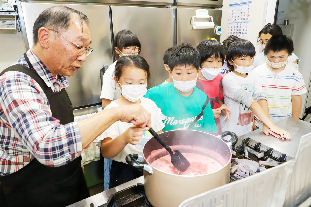 子どもたちとイチゴを煮詰める武内さん（左）