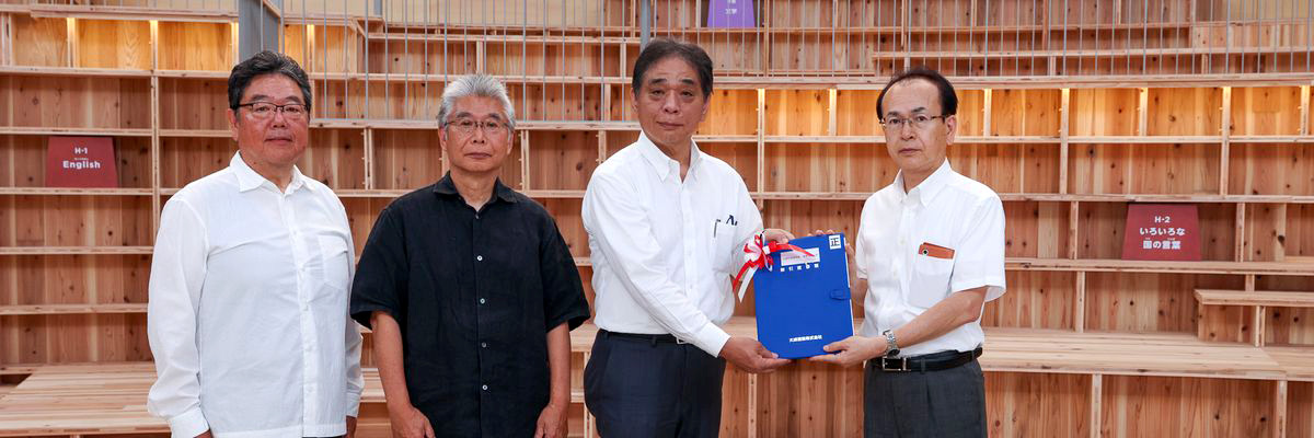 吉田町長に完成図書を手渡す西岡支店長（右から2人目）