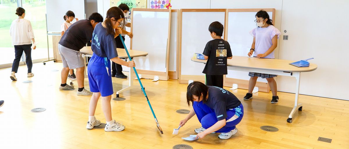 町役場の多目的ホールを掃き掃除する生徒ら