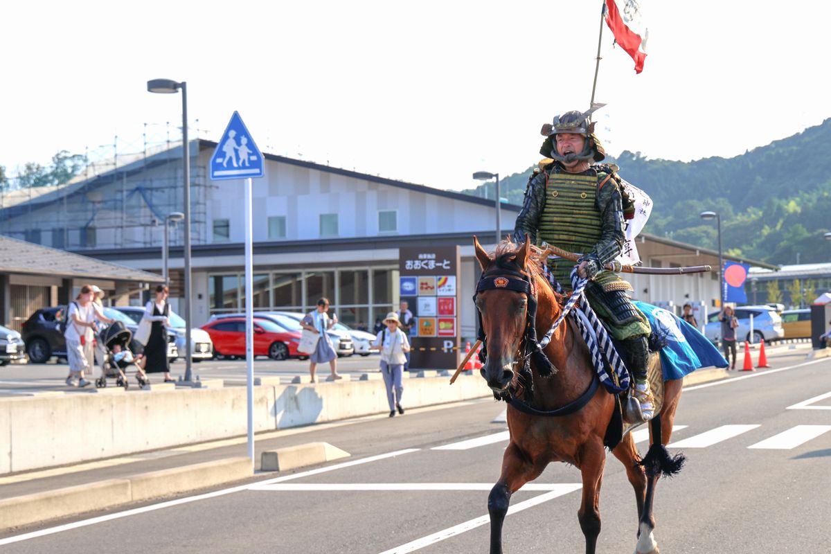 町役場前の町騎馬会本陣で待つ吉田町長に進行状況を報告後、隊に戻る小野田会長