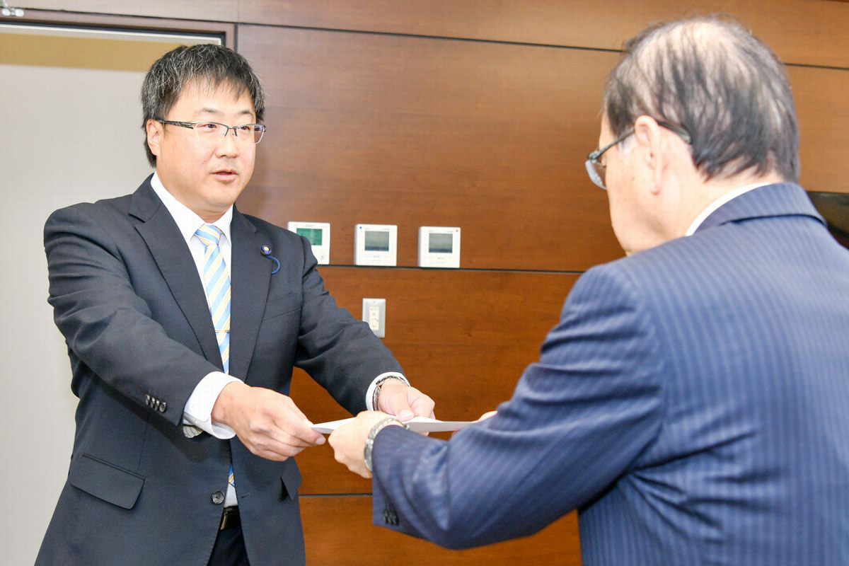 吉田町長から辞令書を受け取る石井委員（左）