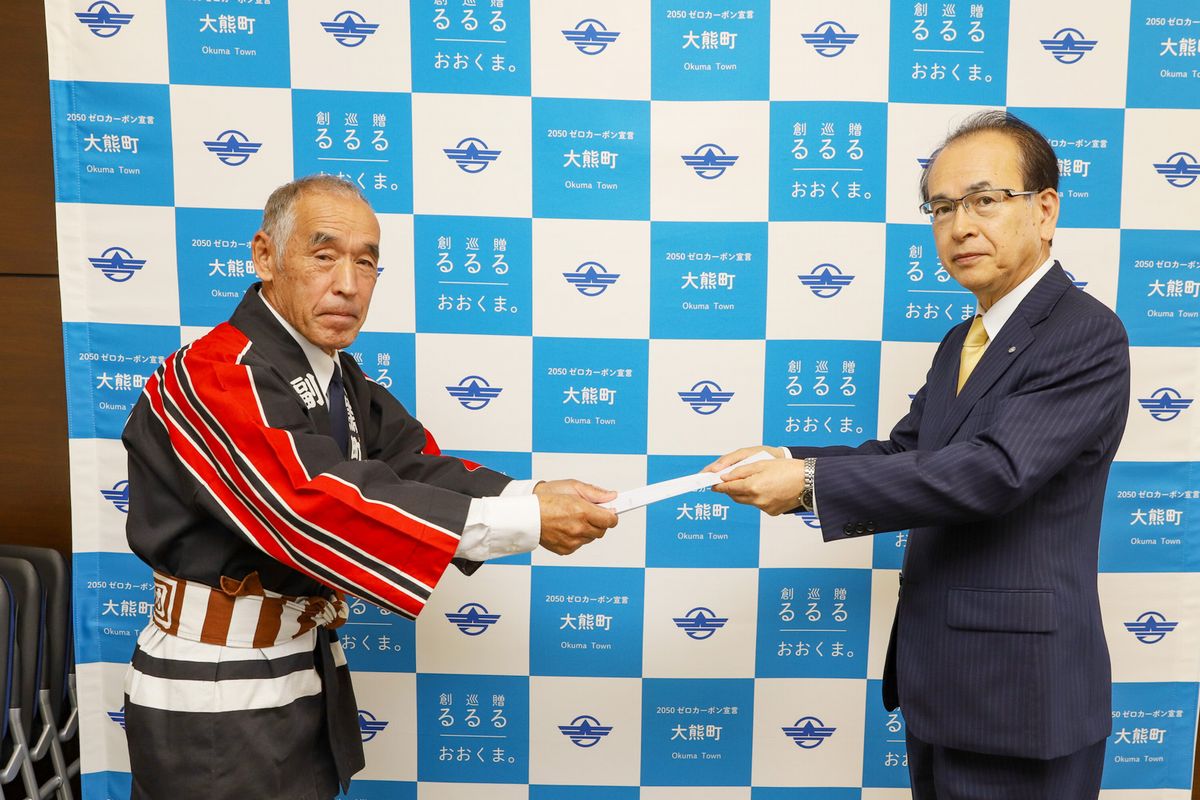 吉田町長から辞令書を受け取る宗像団長（左）