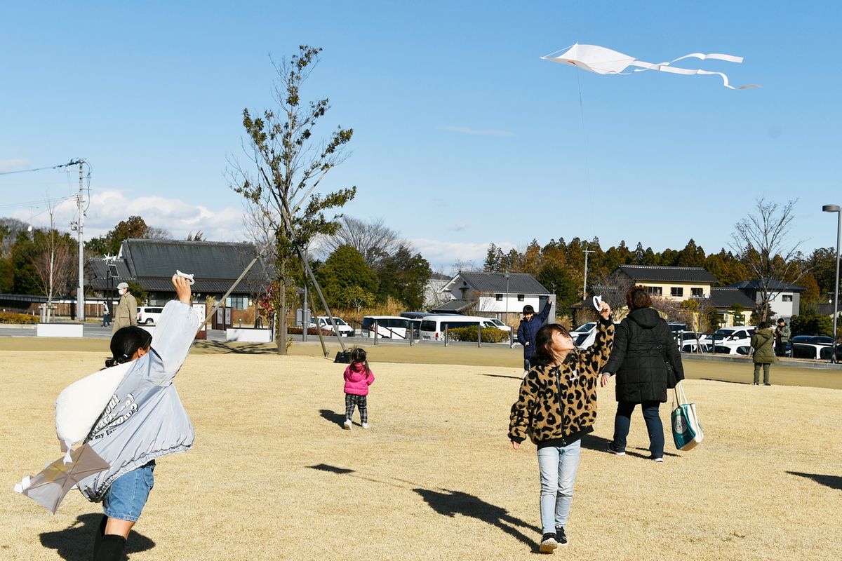 大熊町役場前広場で凧揚げを楽しむ子どもたち。