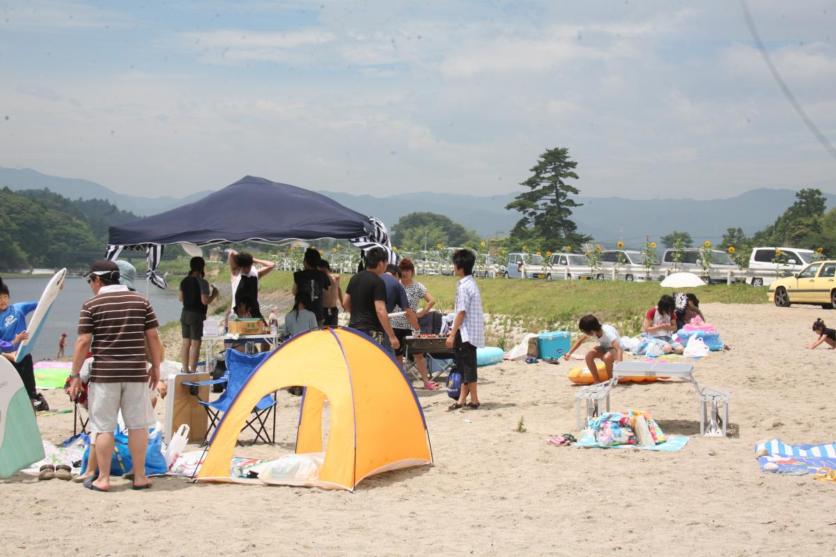 浜辺でバーベキューを楽しむ海水浴客ら