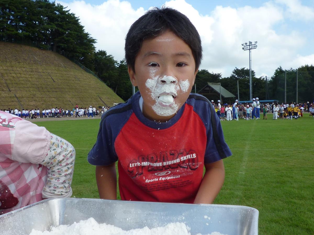 鼻も口も頬も粉だらけになりゴールを目指す小学生男子