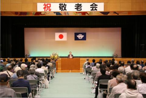 「皆さんの長寿に心よりお祝いを申し上げます。これからも、住んで良かった、生まれて良かったと思える町づくりをしていきます」と式辞を述べる渡辺町長と招待された敬老会の皆さん