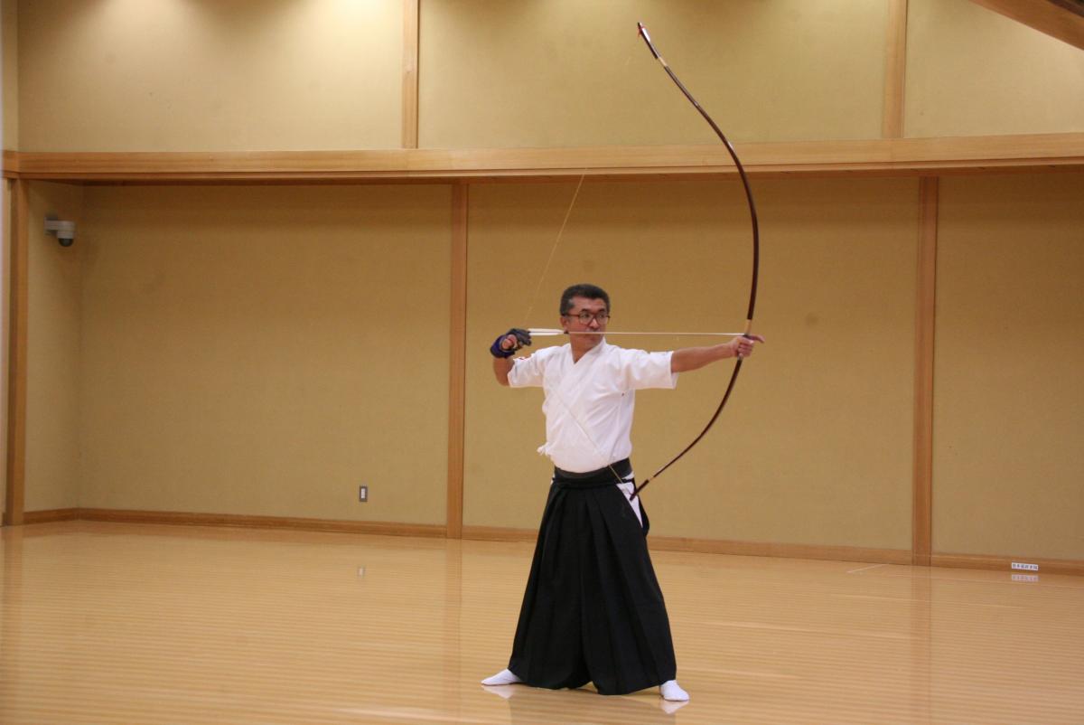 真剣な表情で弓を引く弓道大会男子の部の選手