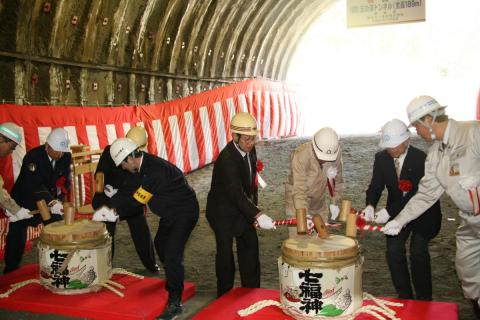 トンネル内で行われた貫通式で鏡開きを行う渡辺町長ら