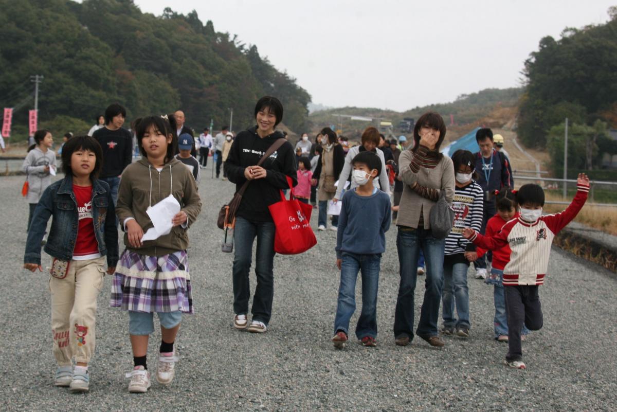 完成前の常磐道を家族で歩く地区住民たち