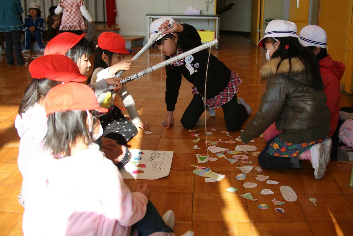 上手な釣り方を園児に教えてあげる小学生