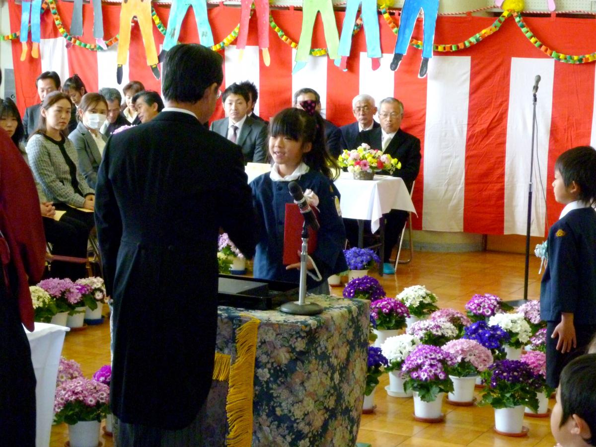笑顔で園長先生と握手をする園児