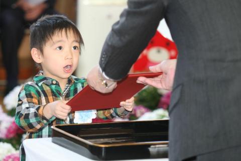 佐々木所長から終了証書を受け取り大きな声で返事をする児童