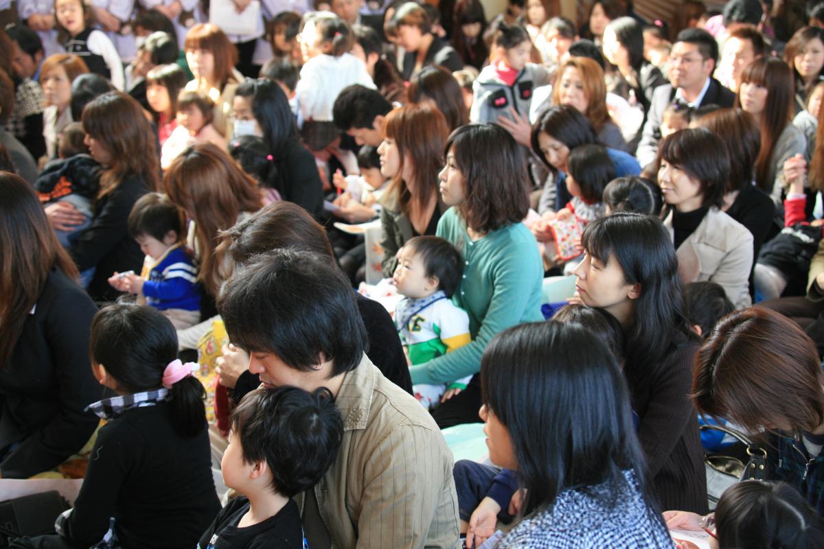 お父さんお母さんのひざに座り、お話を聞く子どもたち