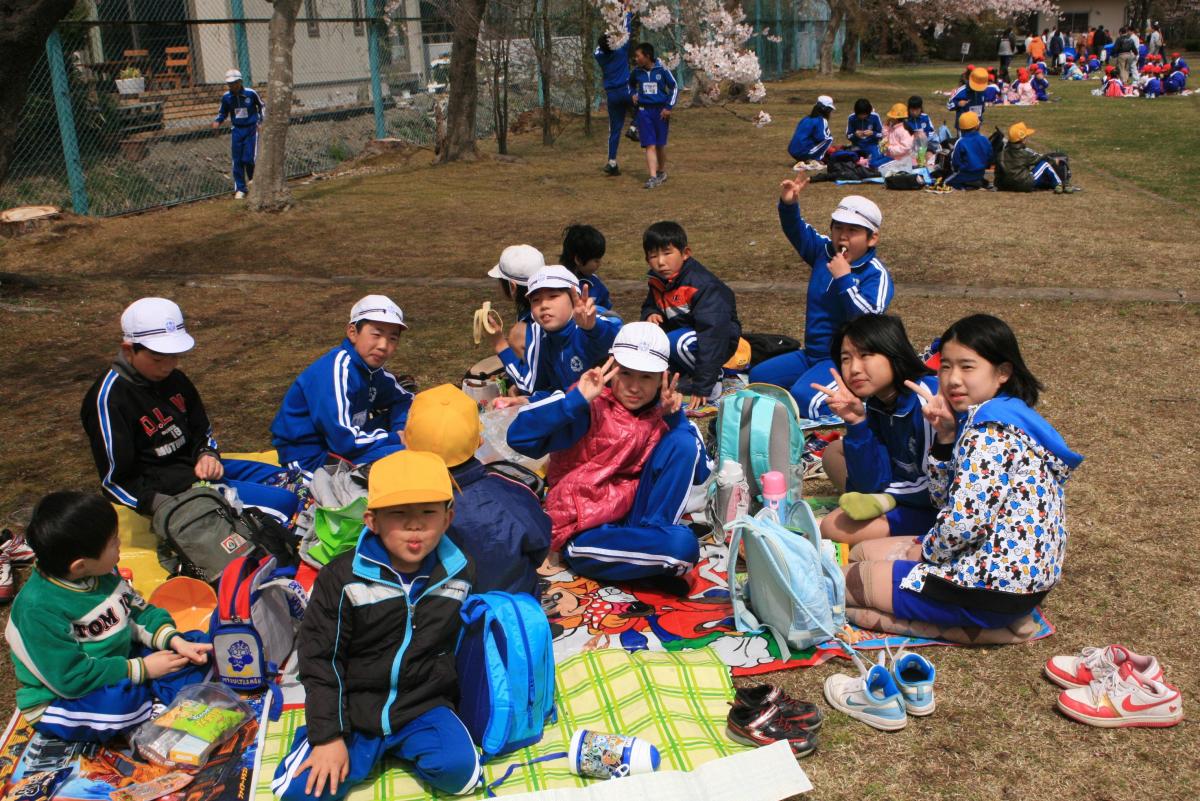 夜の森公園でお弁当やお菓子を食べる子どもたち