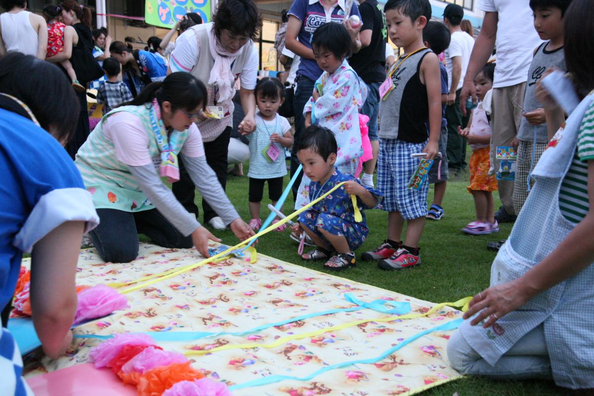 千本釣りのひもをワクワクした様子で引く園児