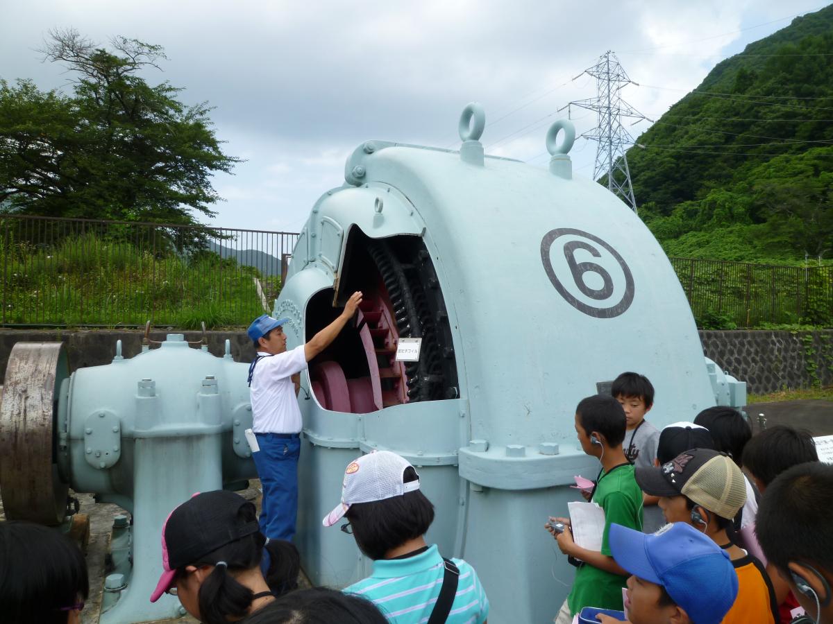 水車の働きの説明を熱心にメモを取りながら聞く子どもたち