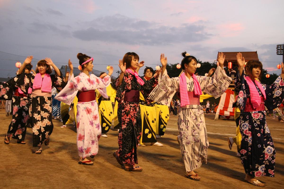 色とりどりのあでやかな浴衣姿で盆踊りを楽しむ町民たち