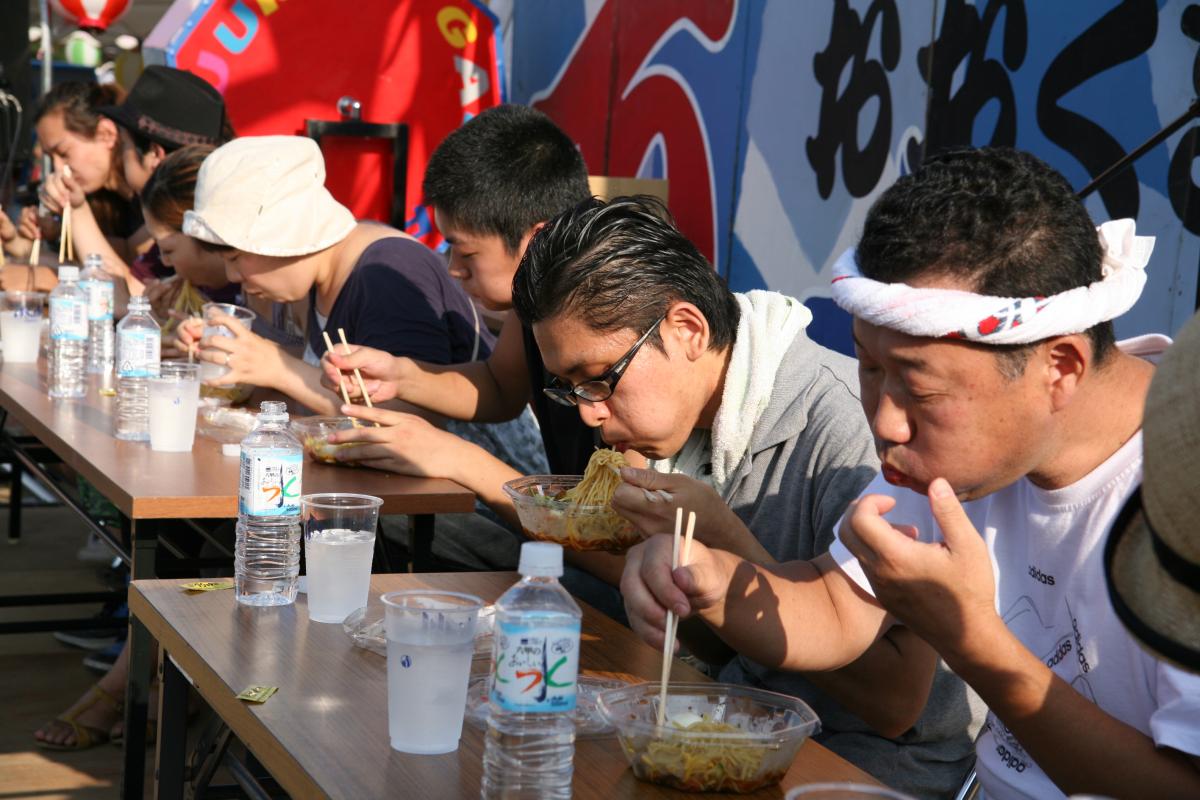 「激辛冷やし中華早食い大会」口いっぱいに頬張り優勝を目指す参加者たち