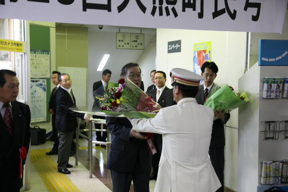 出発式で駅長から花束を受け取る渡辺町長