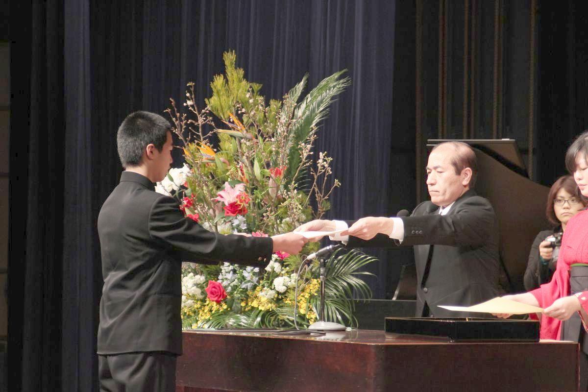 会津若松市文化センターで行われた卒業式で校長から卒業証書を受け取る卒業生