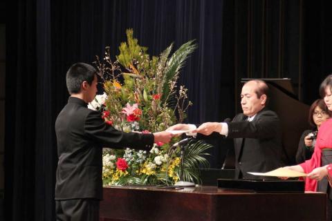 会津若松市文化センターで行われた卒業式で校長から卒業証書を受け取る卒業生
