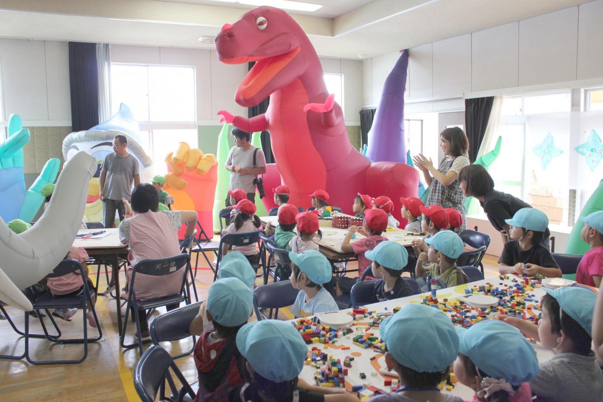 恐竜やゾウなどのバルーンロボットを見て歓声を上げる園児たち