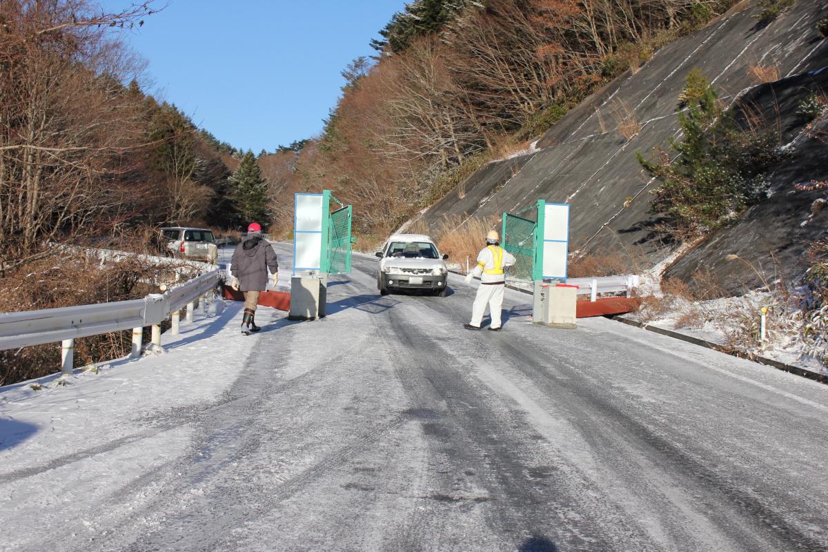 立ち入りの許可を受けた車が通行する中屋敷のバリケード