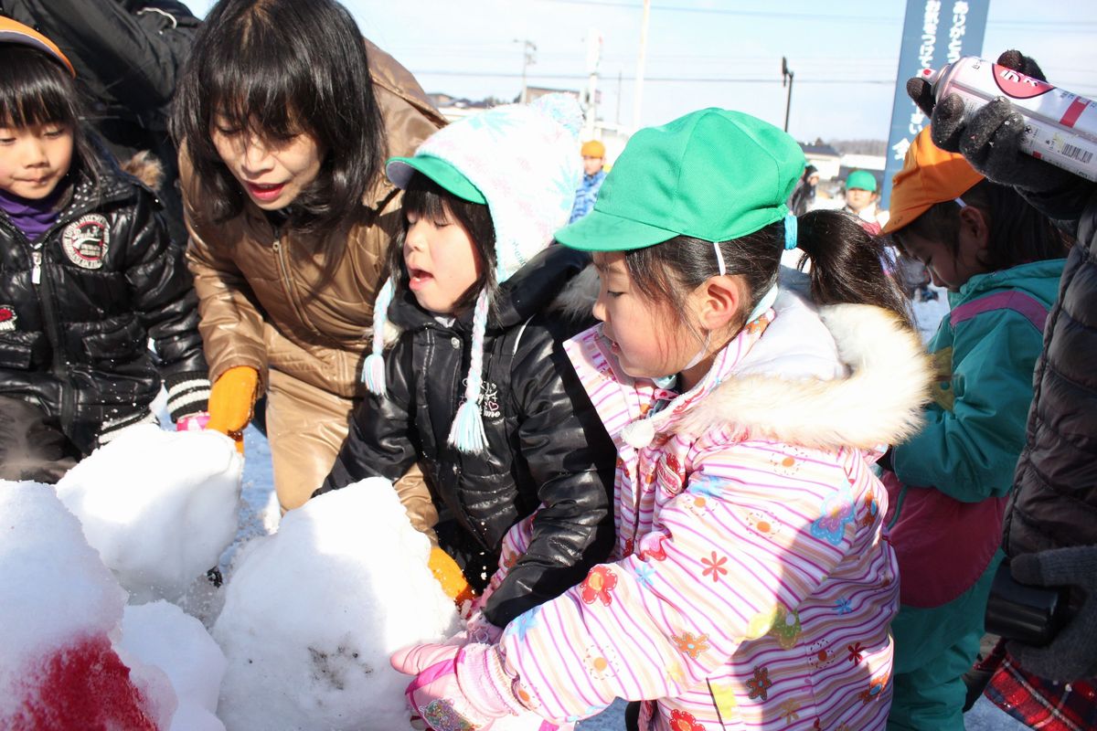 雪を集め雪像を作る園児たち