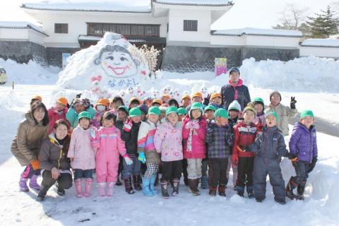 会津村に作った起き上がり小法師の雪像の前で園児全員で記念撮影