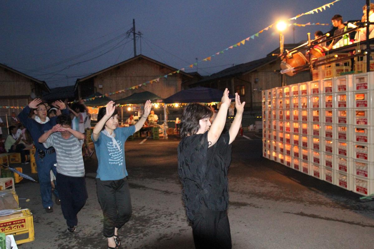 夏の夜空を照らす祭りの明かりと盆踊りの輪