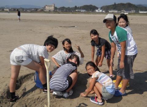 四倉海岸で、みんなで協力して砂の芸術を作る参加者