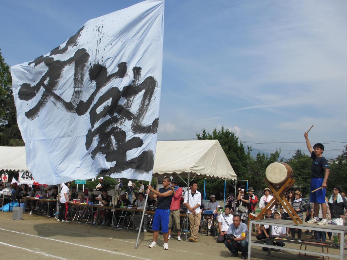 「組体操男塾」の応援旗を掲げる児童と和太鼓で号令をかける児童