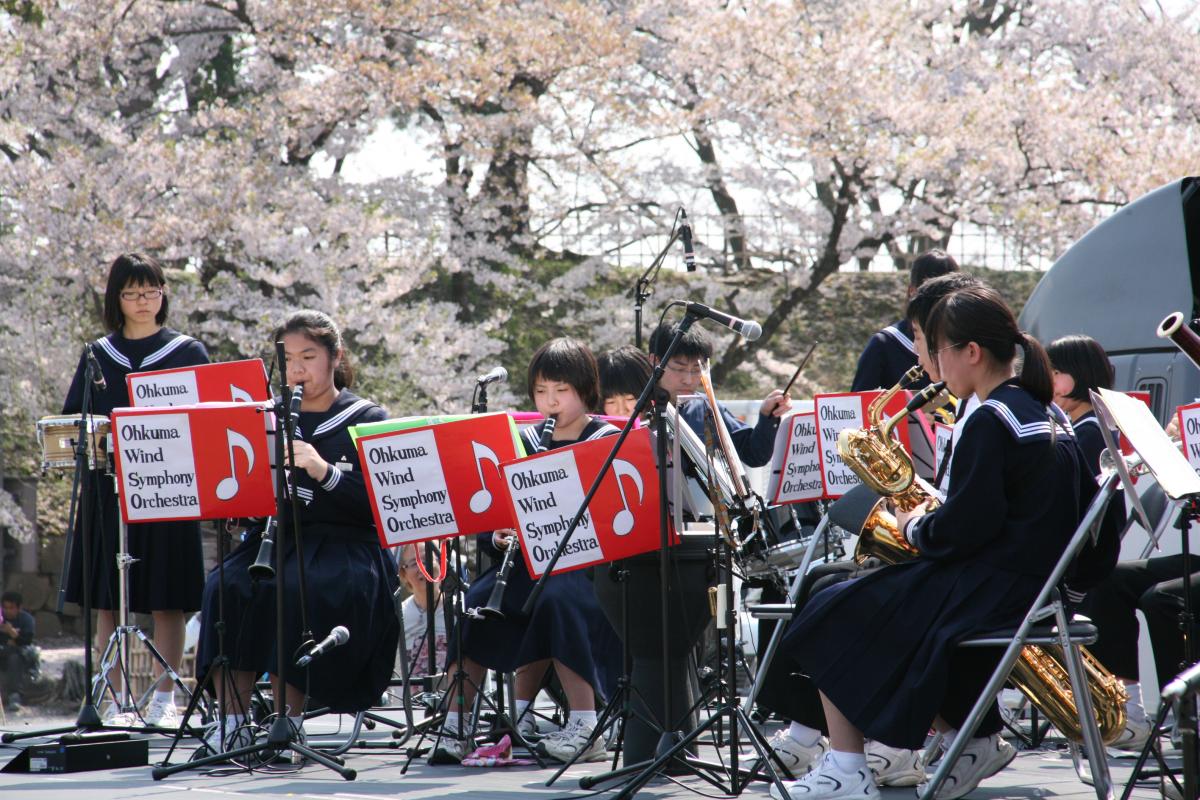 満開の桜のそばで練習の成果を発揮する大熊中吹奏楽部の生徒たち