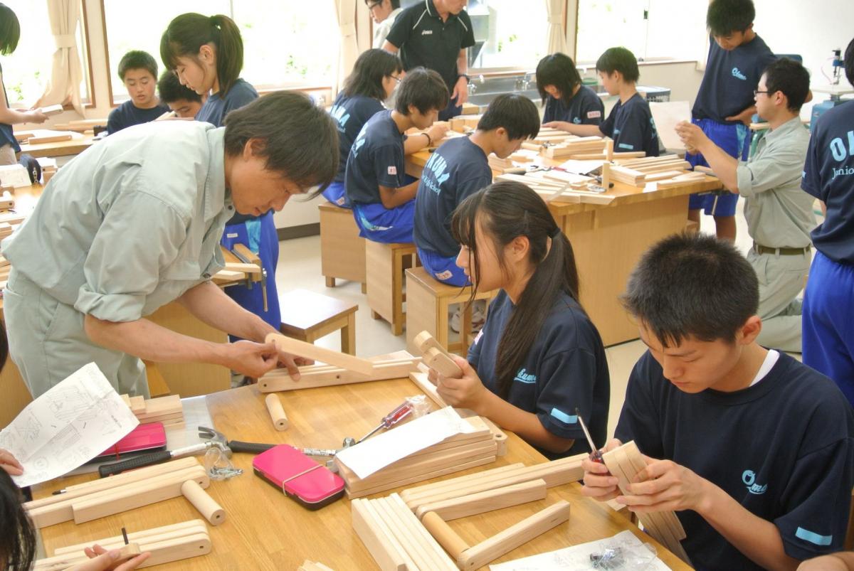 県内産のスギの間伐材を材料にしたキットで折りたたみいすを制作する中学生