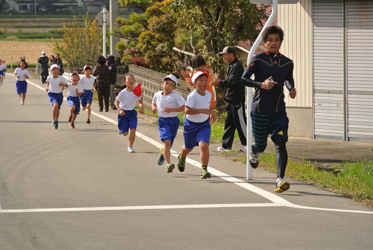 保護者の応援の中を走る児童
