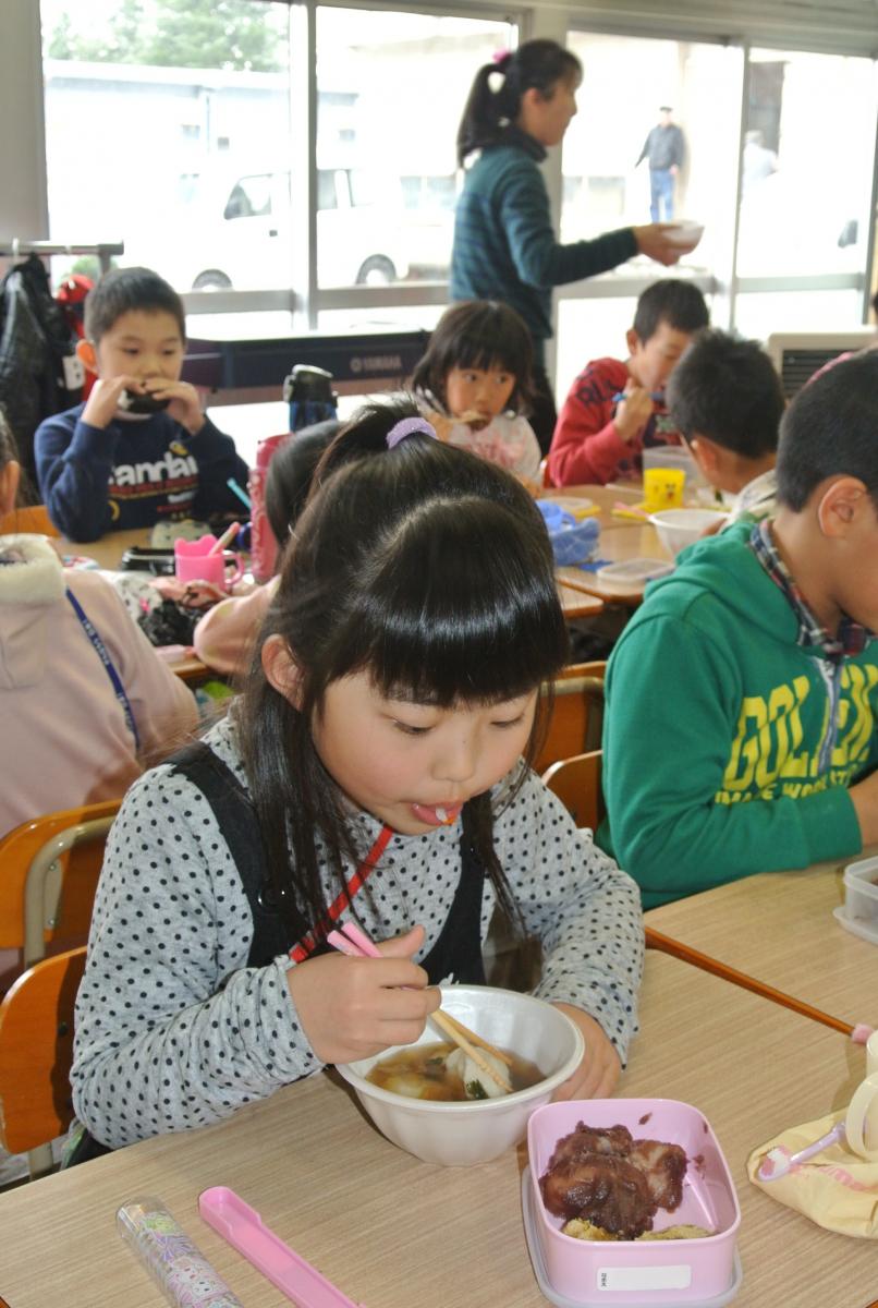 児童は自分たちでついたもちをおいしそうに食べ、一足早い正月気分を味わう児童