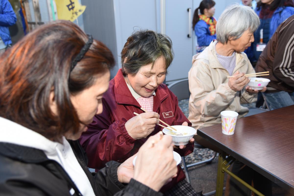 中学生が作ったオリジナル鍋を美味しそうに味わう住民たち