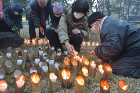 町役場会津若松出張所前庭で行われた3・11追悼および復興イベントで並べたろうそくに火を灯す参加者