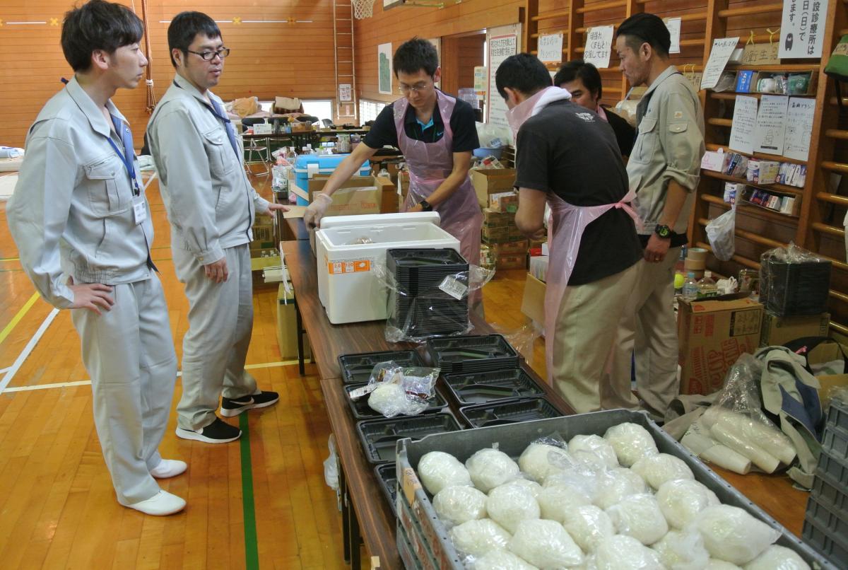 避難所となった白水小体育館で夕食の準備をする応援職員