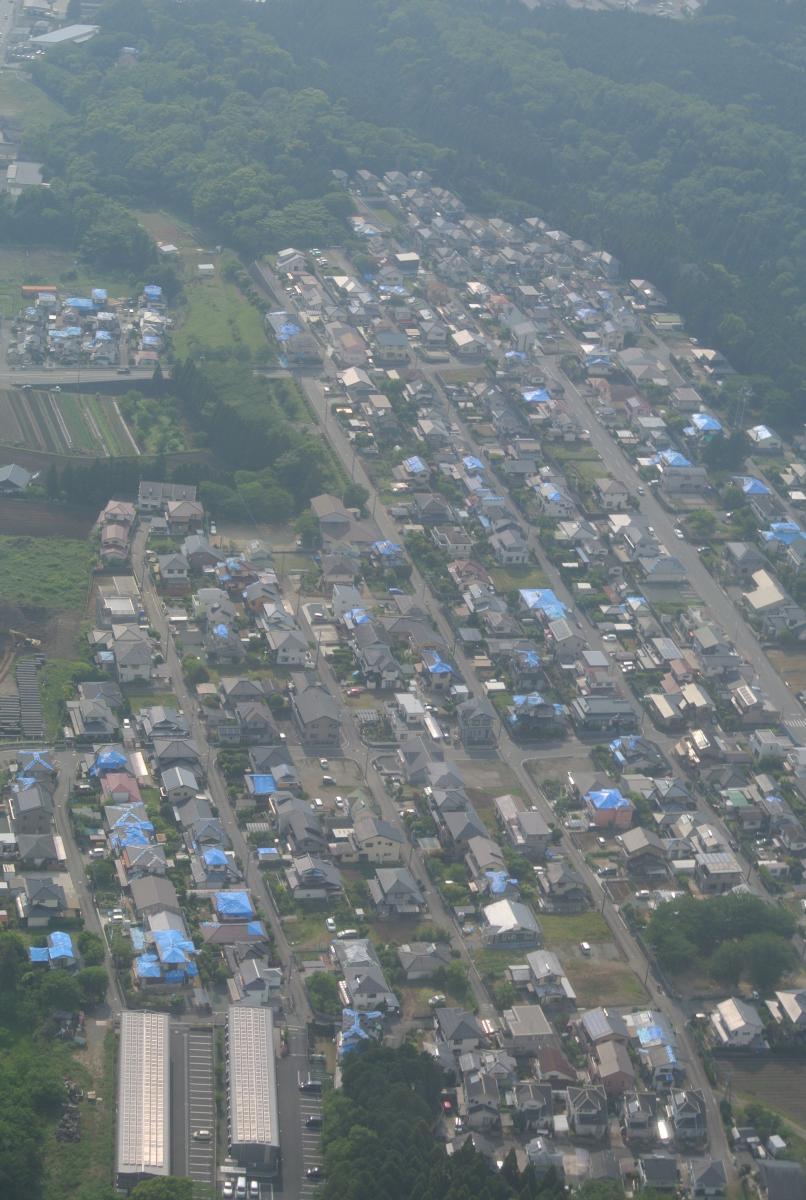 上空からの熊本市の様子。屋根にブルーシートがかかる家屋が目立つ