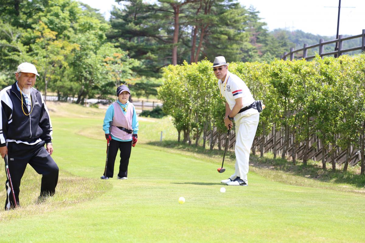 優勝を目指し真剣にプレーする参加者と見守る他の参加者