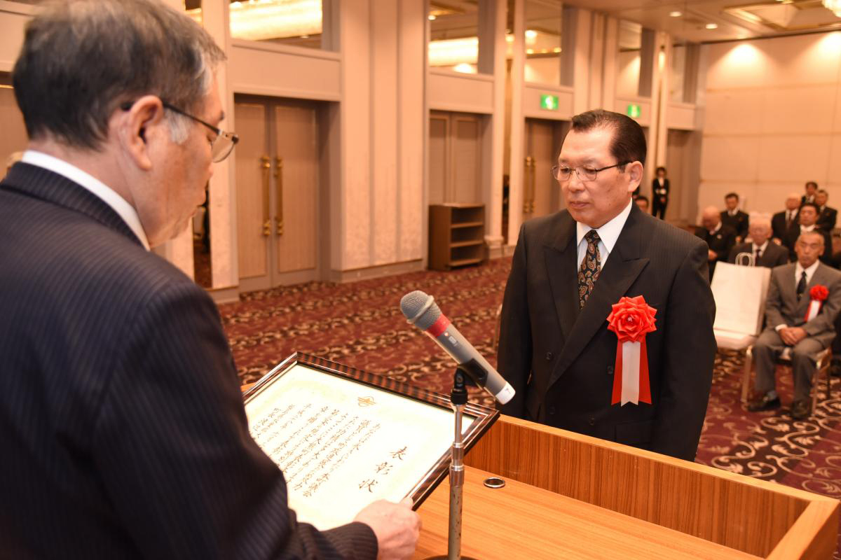 渡辺町長から賞状と記念品を受け取る受章者