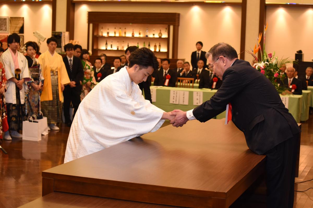 謝辞を述べたあと、渡辺町長と固く握手を交わす新成人代表