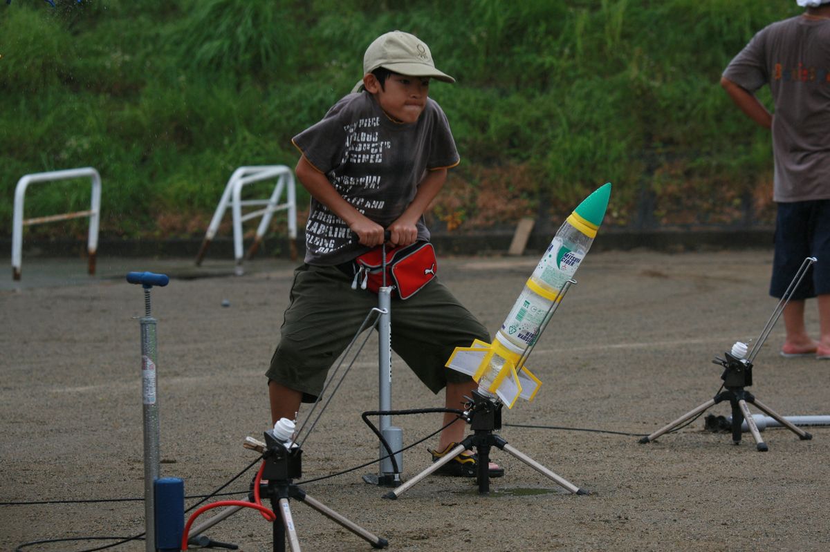 必死に自転車の空気入れを漕ぐペットボトルロケット大会の出場者